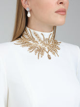 Load image into Gallery viewer, Close-up of embellishment on Dina Melwani ivory high-neck gown with gold embroidery
